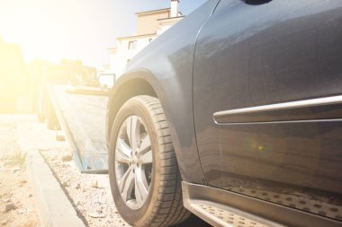 Yol kenarındaki bir çekiciye bozuk araba yüklemek. Araba arızaları yolda. Motor ve arabanın zamanında bakımı.