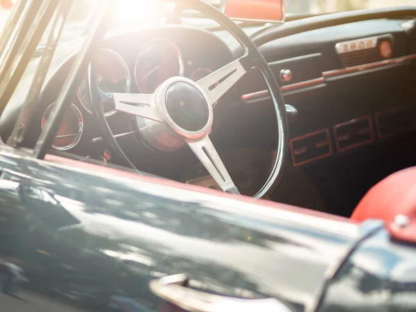 Classic retro cabrio car red leather interior. Vintage steering wheel against the sun. Summer vibes.