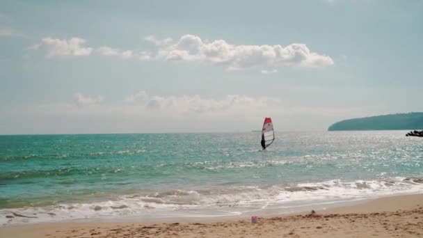 Windsurfer Manejando Una Vela Una Tabla Windsurf Mientras Flota Cerca — Vídeos de Stock