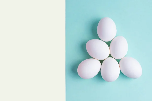 Beyaz tavuk yumurtaları arka planda gruplandırılır.