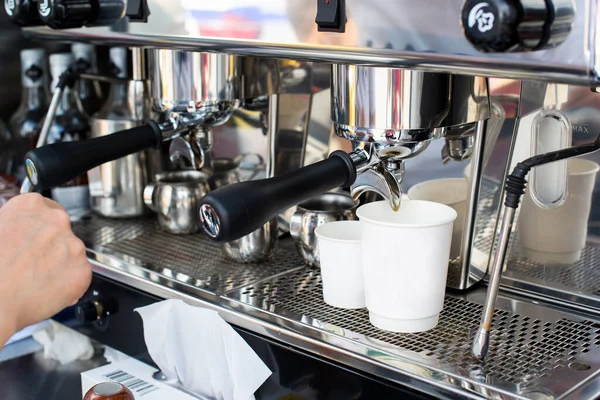 Kahve makinesi ve iki sütlü kahve fincanı.