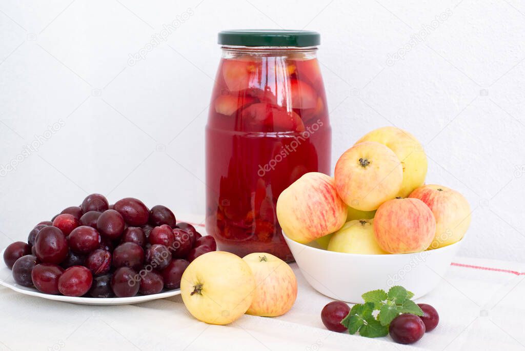 plums, apples and compote on a light background