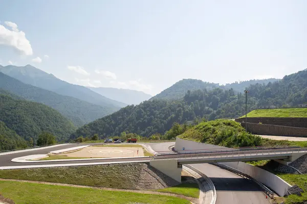 Dağlarda arabalarla asfalt yol ve köprü.