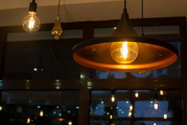 Akşamları bir kafede parlak bir lamba olan tavan lambası.