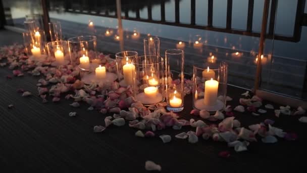 Las velas están en el suelo con pétalos de rosa. Noche romántica. — Vídeos de Stock