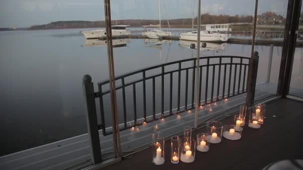 Brennende Kerzen auf dem Boden. Brennende Kerzen in einem transparenten Glasleuchter auf dem Boden sind brennende Kerzen in eleganten Glasvasen. Kulisse für Romantik — Stockvideo