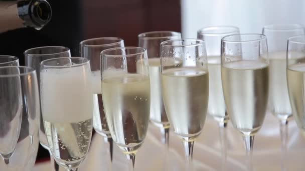 Le serveur verse du champagne dans des verres. Le barman verse du champagne dans des verres. Verser du champagne dans un verre debout sur la table — Video