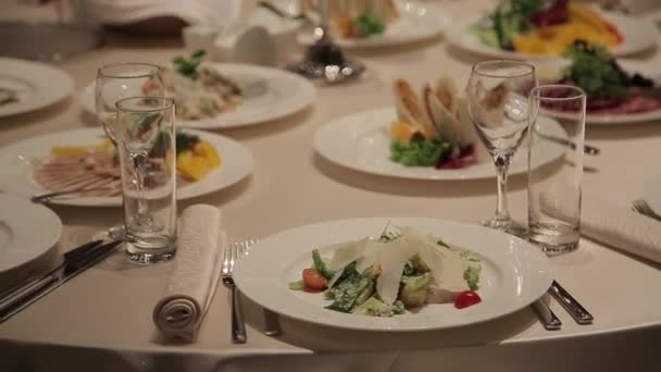 Feestelijk banket bij kaarslicht. Diner in een restaurant bij kaarslicht in de schijnwerpers. De sfeer van feest en plezier. — Stockvideo