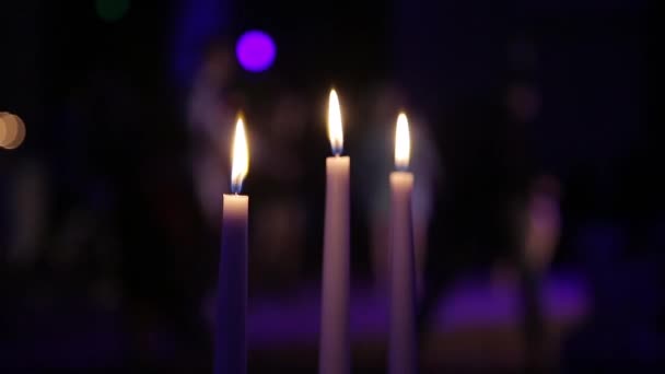 Brennende Kerzen auf dem Tisch vor dem Hintergrund von Silhouetten tanzender Menschen, Restaurantinterieur, Silhouetten tanzender Menschen im Restaurant, geringe Schärfentiefe — Stockvideo