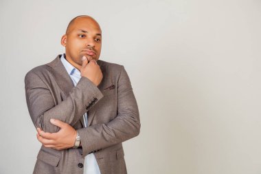 Ciddi endişeli Afrikalı erkek, çenesine dokunuyor, yana bakıyor, ilham için çözüm düşünüyor, düşüncelerde kayboluyor, hayaller kuruyor, başka yöne bakıyor, yaratıcı fikirler arıyor..