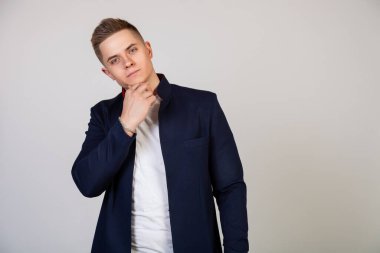 Güzel saç stili olan yakışıklı genç adam yüzünde bir gülümsemeyle kameraya bakıyor. Çekici, yakışıklı, modern serbest çalışan, girişimci ve kameraya bakan öğrencinin fotoğrafı.