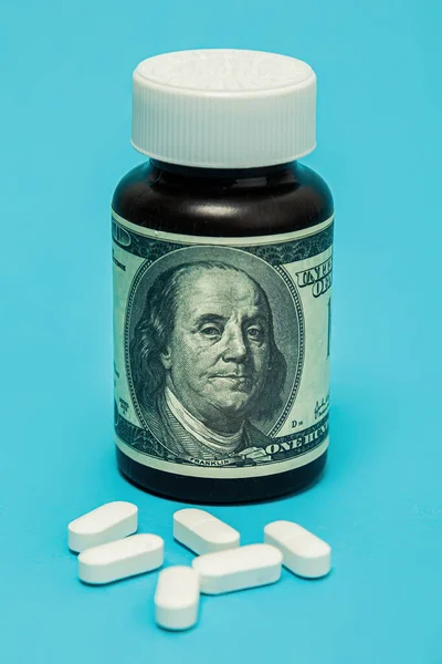 Money and pills of white color on a blue background. The rise in the cost of medical care. The concept of insurance medicine, insurance, high cost, high cost of drugs. — Foto de Stock