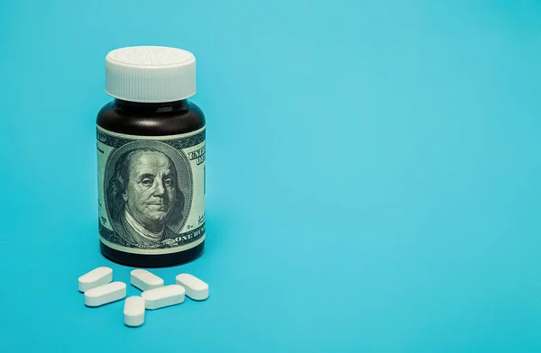 Money and pills of white color on a blue background. The rise in the cost of medical care. The concept of insurance medicine, insurance, high cost, high cost of drugs. — Stockfoto