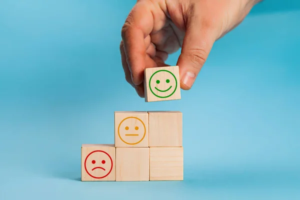 La mano sceglie la crescita faccina sorridente sul cubo del blocco di legno, la migliore esperienza di cliente eccellente di valutazione dei servizi aziendali, concetto di indagine di soddisfazione — Foto Stock