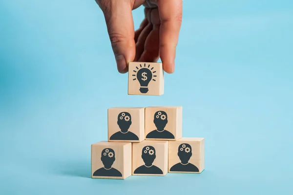 Концепция творческой идеи и инноваций. Выбранный вручную деревянный кубический блок с головой человеческий символ и значок лампочки — стоковое фото