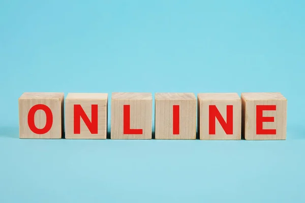 ONLINE - μια λέξη από ξύλινα μπλοκ με γράμματα. Online αναπτυσσόμενη επιχειρηματική ιδέα. Η φράση σε απευθείας σύνδεση από ξύλινα μπλοκ σε μπλε φόντο Royalty Free Φωτογραφίες Αρχείου