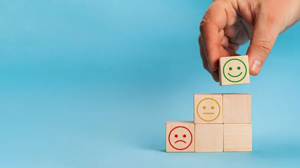 Hand choisit la croissance du visage souriant sur cube de bloc de bois, Le meilleur exc Images De Stock Libres De Droits