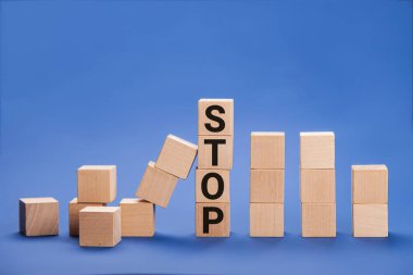 Stop wording print on wooden block cube protect wooden falling domino for risk management concept