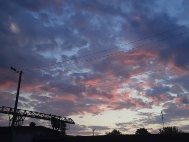                                           Bir yaz akşamı günbatımını ve büyük bulutları tasvir eder.      