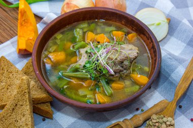 Et ve sebze çorbası. Dilimlenmiş havuç, patates, domates ve etten oluşur.