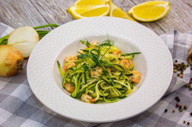 Beyaz tabakta karidesli kabaklı makarna.