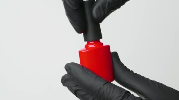 Manicure abre uma garrafa de polonês de gel vermelho clássico. de perto — Vídeo de Stock