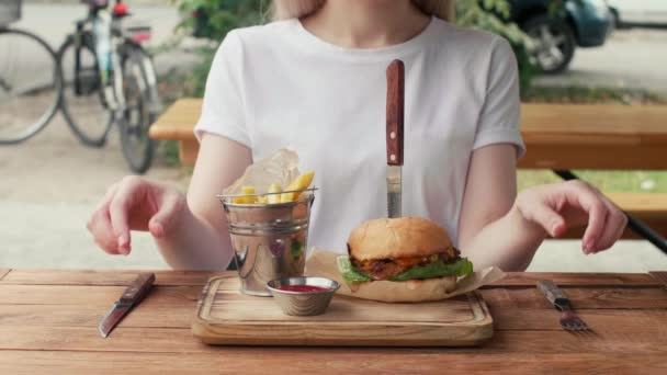 Girl White Shirt Takes Fork Knife Her Hands Eat Burger — ストック動画