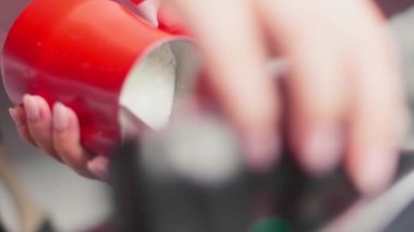 Barista süt buharı yapıyor. Kahveci latte hazırlıyor. Kahve içeceğim. Sütlü. Yakın plan. Kahve makinesinden çıkan sıcak buharla sürahiye süt döker. Süt köpüğü yapma süreci.