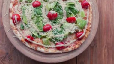Close-up of a delicious pizza with mozzarella cheese and herbs straight from the oven. Delicious italian pizza - food and drink 4k footage