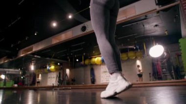Güneş ışınlarında ip atlayan genç bir kadın. Dişi bacaklar ip atlıyor, ip atlıyor, yakın plan çekiliyor. Sağlıklı bir yaşam tarzı. Parktaki mutlu kadın. Sağlıklı yaşam kavramı. Yavaş çekim.