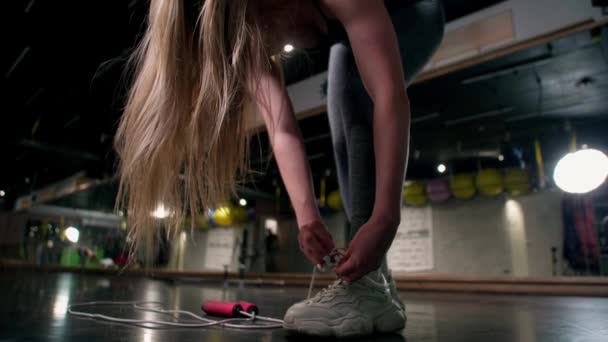 Gri Eşofmanlı Dar Bacaklı Atletik Kadın Spor Ayakkabısının Bağcıklarını Düzeltiyor — Stok video