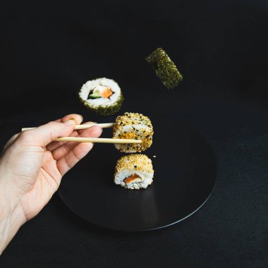 Suşi rulo kümesi üzerinde koyu arka plan.