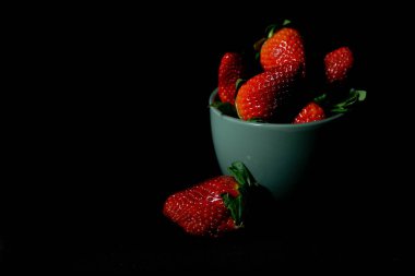 Siyah arka planda olgun çilekler