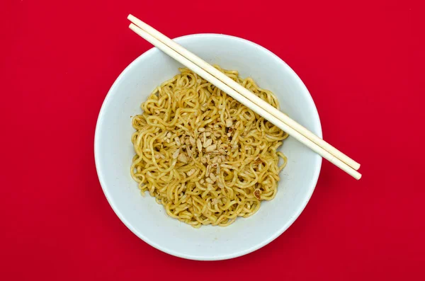 Kırmızı arka planda çubuklu hazır erişte.