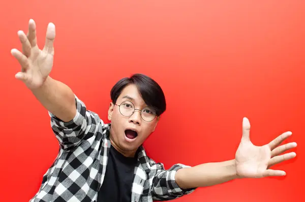 Wow and surprised face of young asian man feeling happy, excited and positive. asian man open arms for a hug and giving surprise gesture.