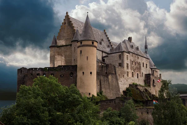 Arkasında karanlık bir gökyüzü olan güzel Vianden Kalesi, Lüksemburg. Önünde doğa olan Vianden Şatosu. 