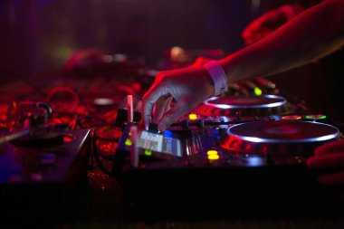 Sahne alırken bir DJ 'in ellerini mikseri çalarken yakın çekimde göster. Yüksek kalite fotoğraf