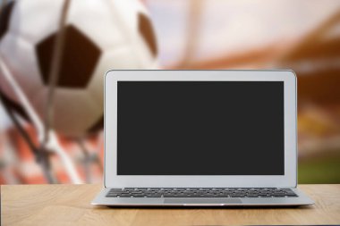 Arkasında bulanık bir futbol stadyumu olan boş ekranlı bir laptop. Kişisel bir resim için kendi resminizi ekrana yapıştırın