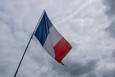 Arka planda kara bulutlar olan Fransız bayrağı.