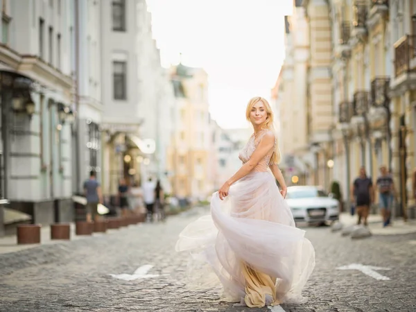 Pěkně usměvavá mladá žena s dlouhými blond vlasy v elegantních letících lehkých šatech — Stock fotografie