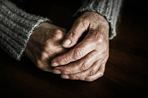 Zamknij Ręce Starszej Kobiety Stole Fotografia Dramatyczna — Zdjęcie stockowe