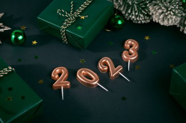 Yaratıcı Yeni Yıl 2023 Noel dekorlu tebrik kartı. Sayısal mumlardan yapılmış sayılar