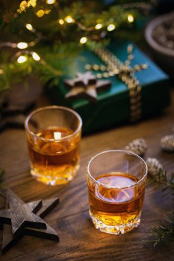 İki bardak viski ya da koyu arkaplanda Noel süsü olan bir viski. Yeni yıl, Noel ve kış bayramı Viski ruh hali konsepti