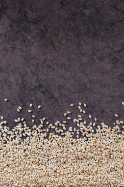 Organik pişmemiş inci arpa manzaralı. Soyut bir doku olarak çiğ arpa gevreği tanecikleri.