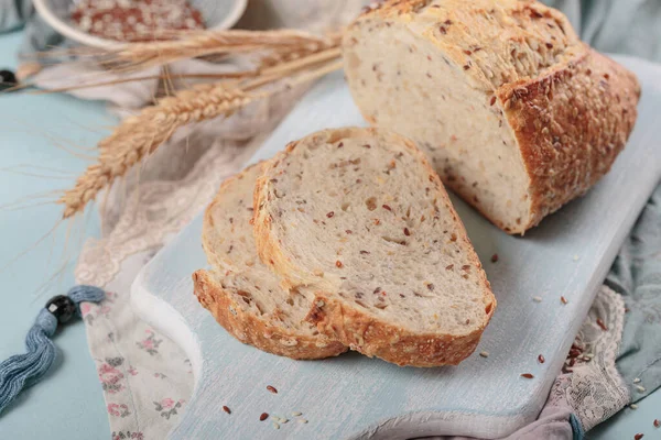 Gesneden Vers Gebakken Volkorenbrood Met Lijnzaad Sesamzaad Lichtblauw Bord Bakkerijproducten — Stockfoto