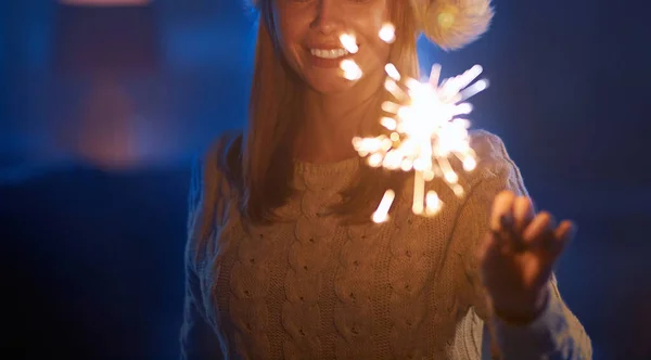 Mujer sonriente usando bengalas mientras celebra el año nuevo —  Fotos de Stock