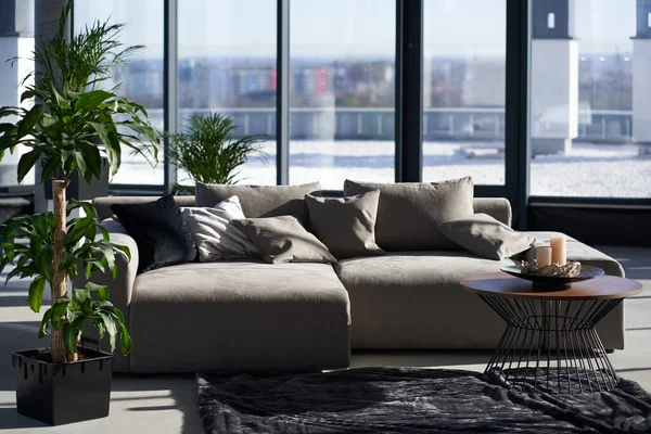 Luxe appartement met grijze bank en panoramische ramen — Stockfoto