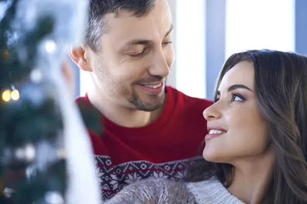 Casal encantador sorrindo e abraçando perto da árvore de Natal — Fotografia de Stock