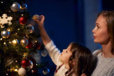 Anne ve kızı evde Noel ağacı süsleme