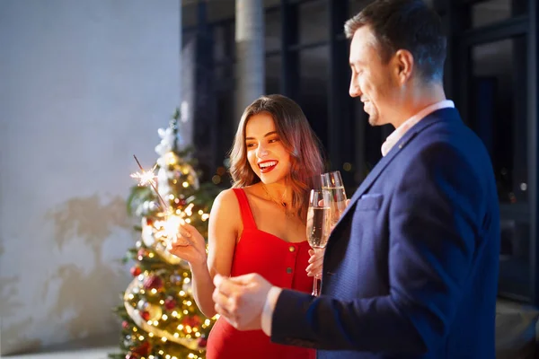 Paar feiert Weihnachten mit Wunderkerzen und Champagner — Stockfoto
